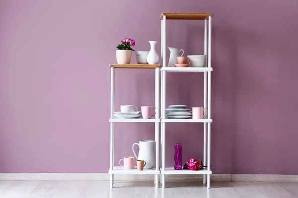 Rack with clean dishes near color wall in kitchen — Stock Photo, Image