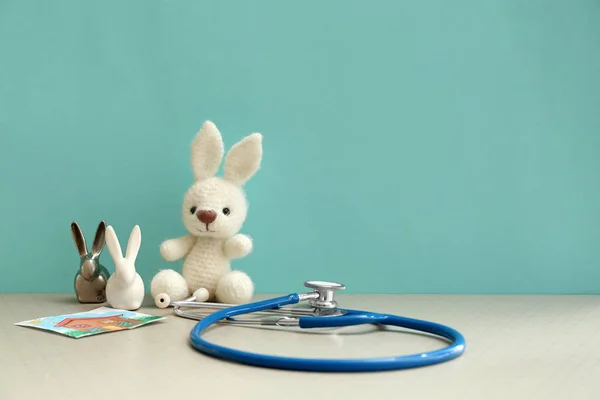 Toy bunnies with stethoscope on table — Stock Photo, Image