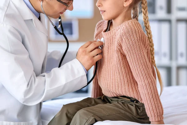 Pediatr vyšetřuje malou holčičku na klinice — Stock fotografie