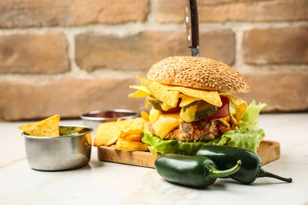 Tasty burger with nachos and guacamole on table — Stock Photo, Image