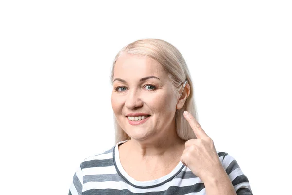 Mujer madura con audífono sobre fondo blanco — Foto de Stock