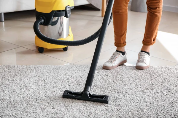 Woman cleaning carpet with hoover at home — Stock Photo, Image