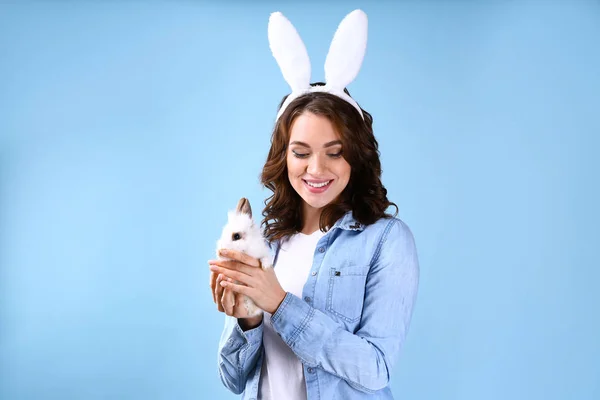 Krásná mladá žena s králíky a roztomilým králíkem z barevného pozadí — Stock fotografie