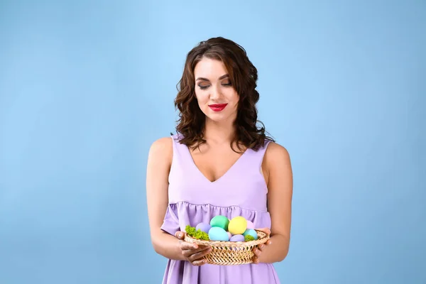 Krásná mladá žena s velikonoční vajíčky na barevném pozadí — Stock fotografie