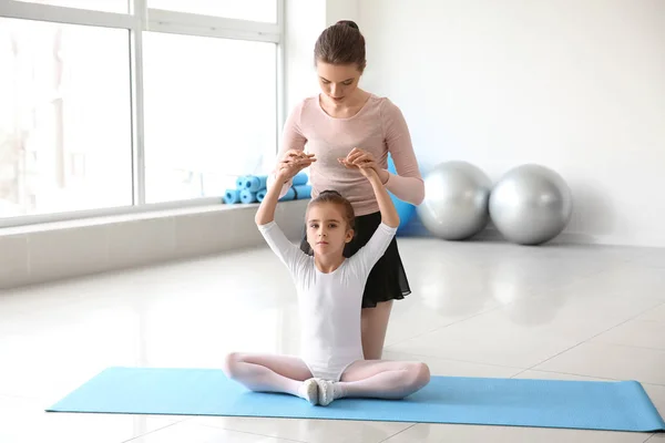 Маленькая балерина тренируется с тренером в танцевальной студии — стоковое фото
