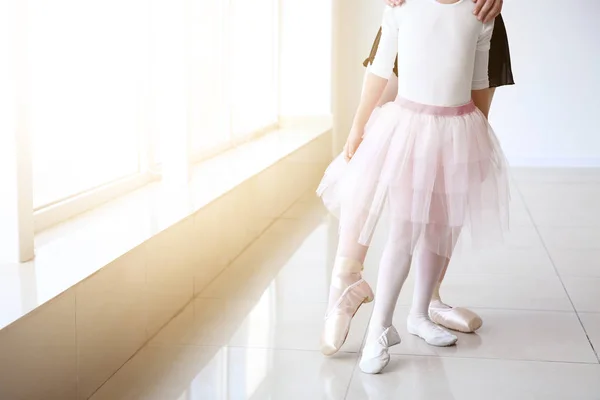 Little ballerina training with coach in dance studio