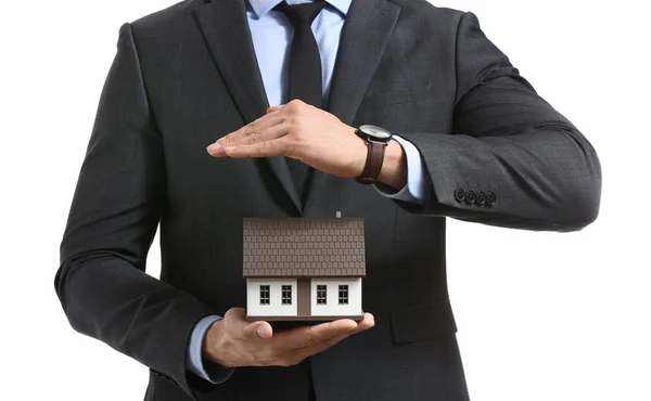 Insurance agent with model of house on white background, closeup. Protection of house from earthquake — Stock Photo, Image