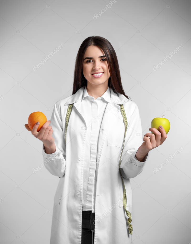 Portrait of female nutritionist on light background