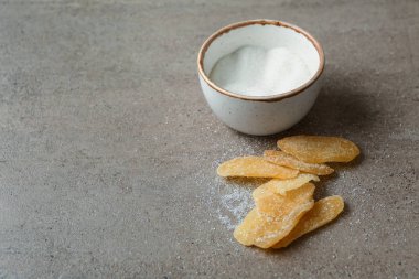 Gri zemin üzerine şeker ile lezzetli kurutulmuş zencefil