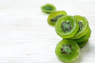 Beyaz ahşap zemin üzerinde kurutulmuş lezzetli kivi