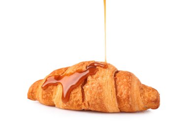 Beyaz arka plana karşı lezzetli kruvasandan Sıvı karamel dökme