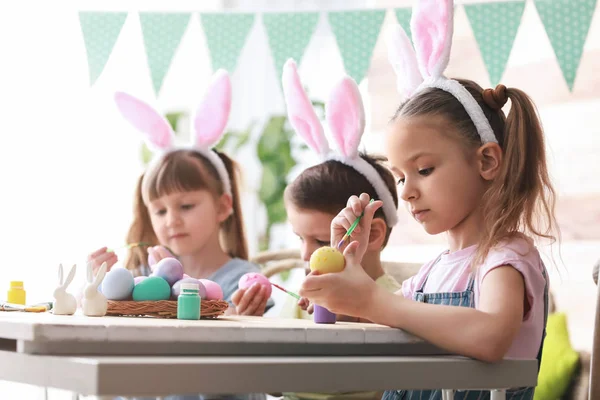 Enfants mignons peignant des œufs de Pâques à la maison — Photo