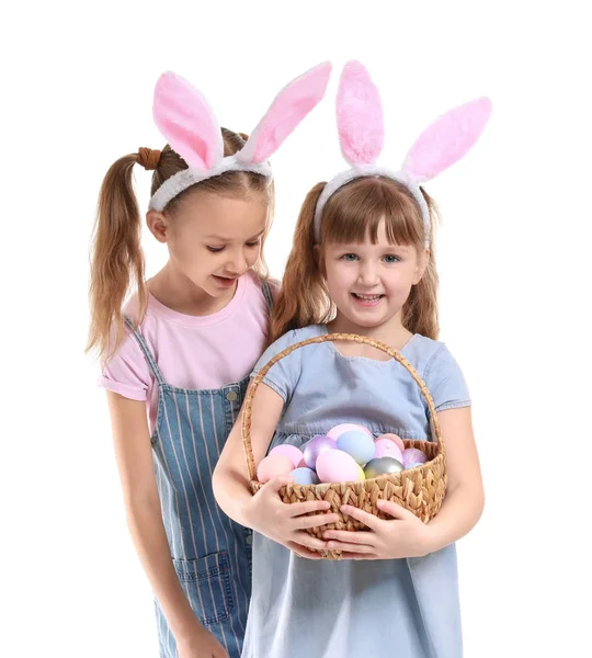 Meninas bonitos com cesta de ovos de Páscoa e orelhas de coelho no fundo branco — Fotografia de Stock