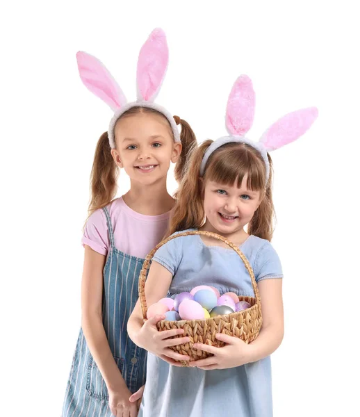 Meninas bonitos com cesta de ovos de Páscoa e orelhas de coelho no fundo branco — Fotografia de Stock