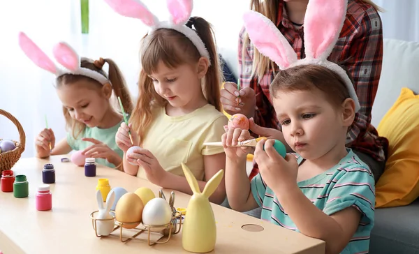 Petits enfants mignons peignant des œufs de Pâques à la maison — Photo