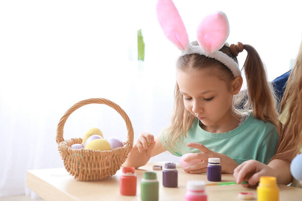 Милые маленькие дети рисуют пасхальные яйца дома
