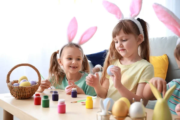 Leuke lieve kinderen thuis paaseieren schilderen — Stockfoto
