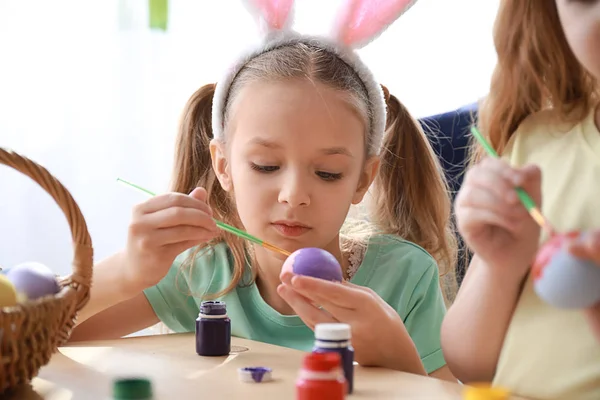 Niedliche kleine Kinder bemalen Ostereier zu Hause — Stockfoto