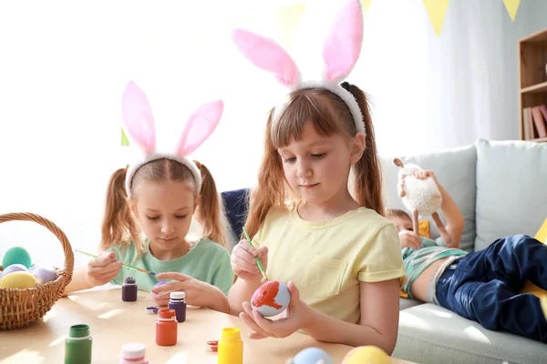 Niedliche kleine Kinder bemalen Ostereier zu Hause — Stockfoto