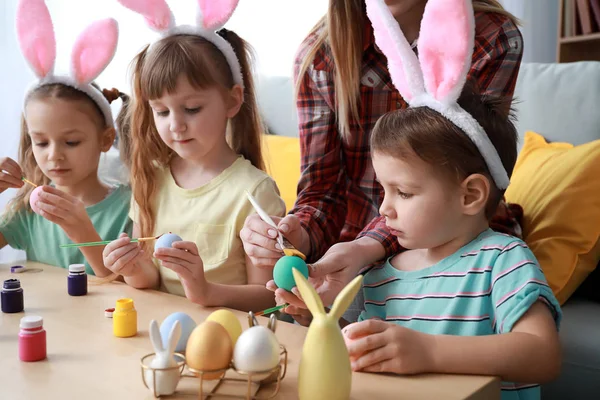Petits enfants mignons peignant des œufs de Pâques à la maison — Photo