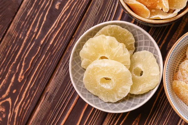 Bowl with tasty dried pineapple on wooden background — Stock Photo, Image