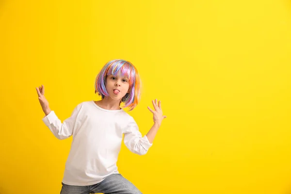 Renk arka plan üzerinde parlak peruk, komik küçük kız — Stok fotoğraf