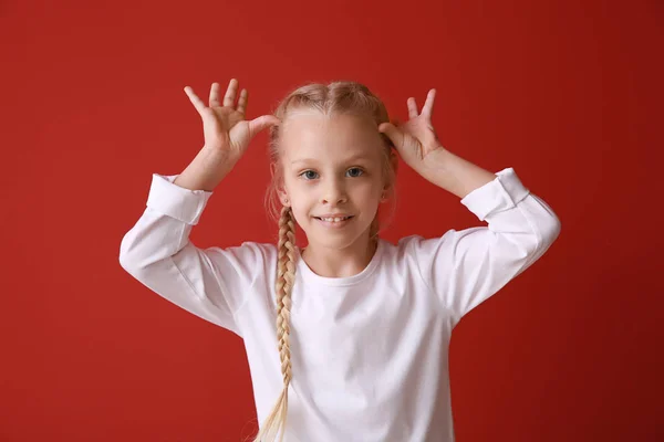 Funny grimacing little girl on color background — Stock Photo, Image