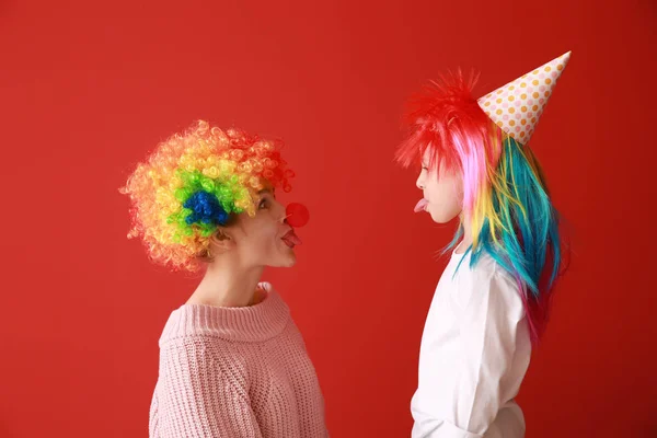 Женщина и маленькая девочка в смешной маскировке на цветном фоне. Празднование Дня дураков — стоковое фото