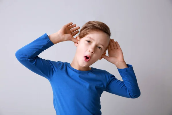 Funny grimacing little boy on light background — Stock Photo, Image