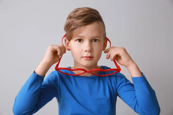 Niño divertido con grandes gafas en forma de corazón sobre fondo claro — Foto de Stock