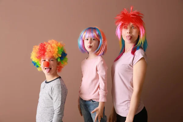 Family in funny disguise on color background. April fools' day celebration — Stock Photo, Image