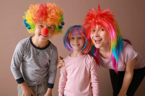 Family in funny disguise on color background. April fools' day celebration — Stock Photo, Image