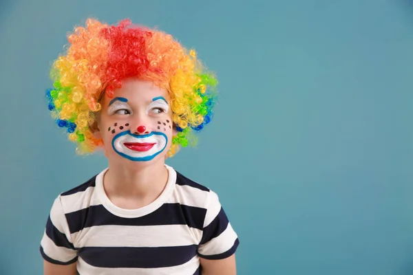 Söt liten pojke med clown makeup på färg bakgrund. April dårar dag firande — Stockfoto