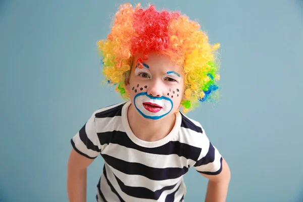 Χαριτωμένο αγοράκι με μακιγιάζ κλόουν στο χρώμα φόντο. Πρωταπριλιά ημέρα εορτασμού — Φωτογραφία Αρχείου