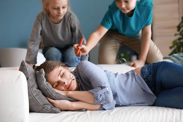 Little children drawing on face of their sleeping mother. April fools' day prank — Stock Photo, Image