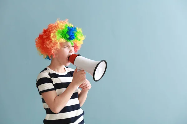 Petit garçon déguisé drôle et avec mégaphone sur fond de couleur. Fête des fous d'avril — Photo