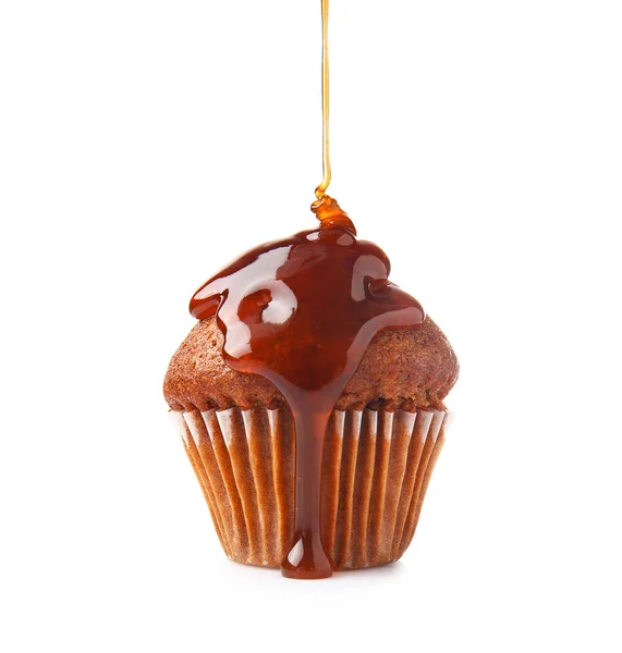 Caramelo líquido derramando sobre muffin contra fundo branco — Fotografia de Stock