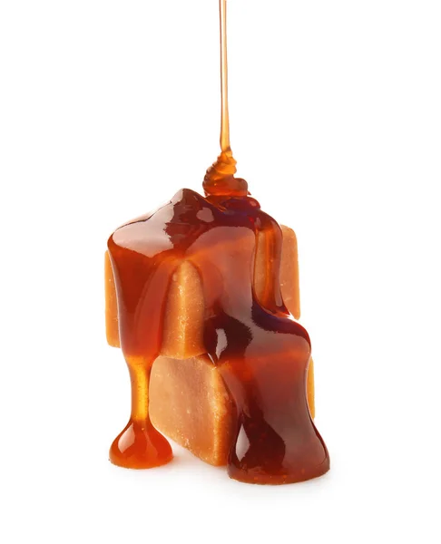 Flytande karamell hälla på godis mot vit bakgrund — Stockfoto