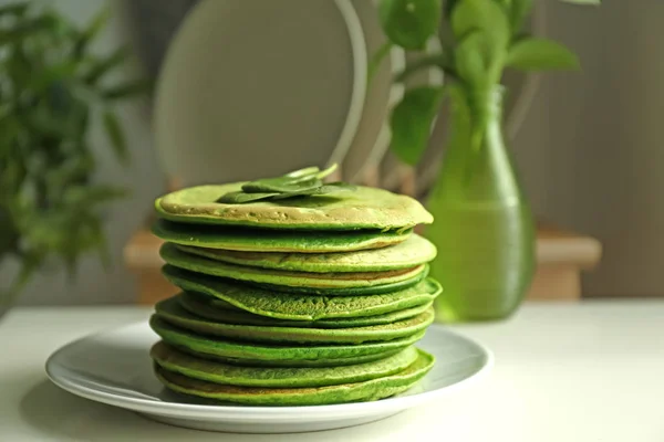 Plate with tasty green pancakes on table in kitchen — Stock Photo, Image