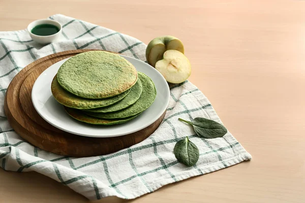 Plate with tasty green pancakes on wooden table — Stock Photo, Image