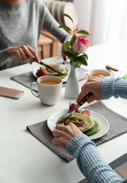 Las mujeres comiendo sabrosos panqueques verdes en la mesa — Foto de Stock