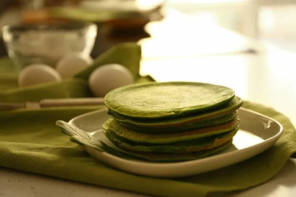 Plate with tasty green pancakes on table in kitchen — Stock Photo, Image