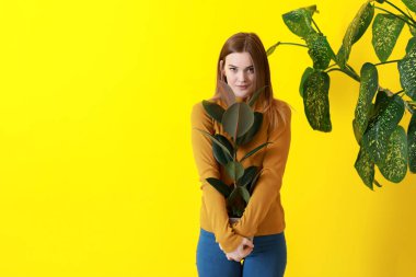 Renk arka plan üzerinde yeşil tropikal bitkiler ile güzel bir kadın portresi