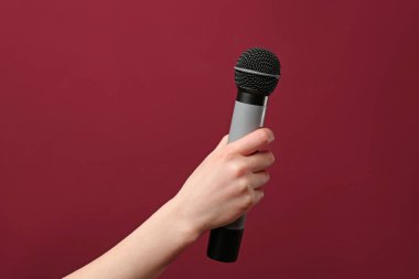 Renkli arka planda mikrofon ile kadın el