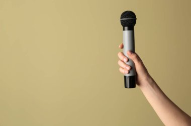 Renkli arka planda mikrofon ile kadın el