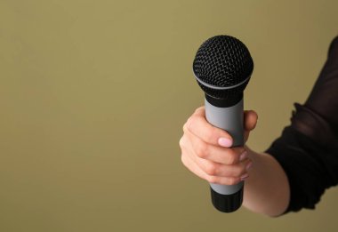 Renkli arka planda mikrofon ile kadın el