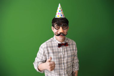 Renk arka planda Nisan Fools ' günü için parti dekor ile komik Asyalı adam