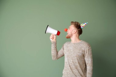 Renkli arka plan üzerinde megafon ile komik adam. Nisan Fools ' gün şaka