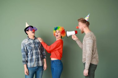 Renkli arka plan karşı arkadaşlarına bağırarak megafon ile komik adam. Nisan Fools ' gün şaka