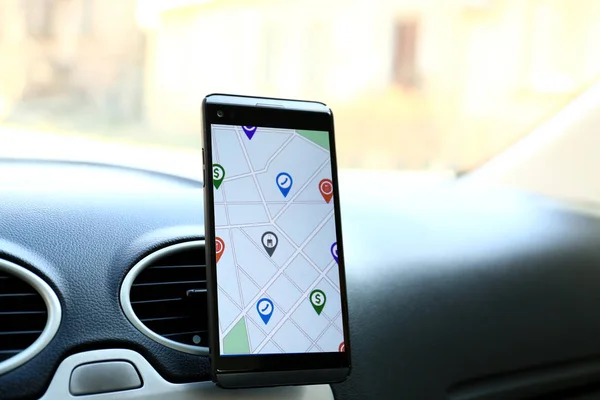 Mobilní telefon zobrazující mapu s ukazateli umístění na obrazovce řidiče auta — Stock fotografie